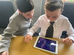 Two young boys studying with a tablet at Inchmarlo School in Aberdeenshire.