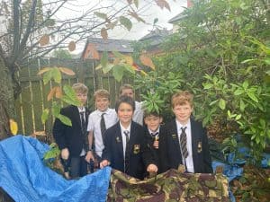 Students exploring outdoor garden areas at Inchmarlo School in a lush, green setting.