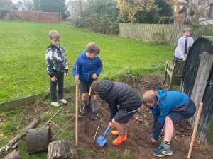 Children planting trees at Inchmarlo estate in Scotland, outdoor community environment, eco-friendly activities.