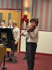 Children playing violin during school concert at Inchmarlo.