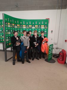 Group of students at Inchmarlo educational event in front of interactive green display panel.