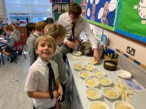 Children enjoying a school lunch with desserts and drinks.