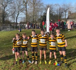 Group of young rugby players in striped jerseys outdoors.