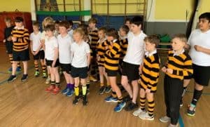Group of children in sports uniforms at Inchmarlo school gym.