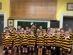 Children in rugby uniforms inside school classroom.