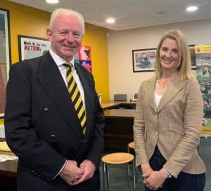Two professionally dressed individuals smiling indoors at Inchmarlo Care Village.