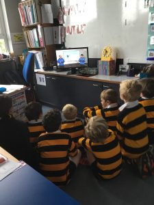 Children watching educational content on a computer in classroom setting.
