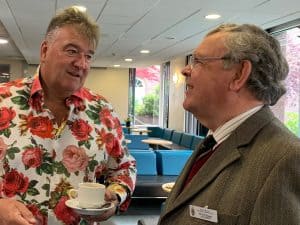 Two men talking at a social event in a modern venue.