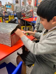 Young student working on a project in a classroom setting at Inchmarlo.