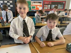 Young students in classroom uniforms at Inchmarlo School, engaging in learning activities.