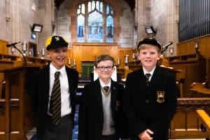 Three boys in school uniforms at Inchmarlo School, standing in classroom.
