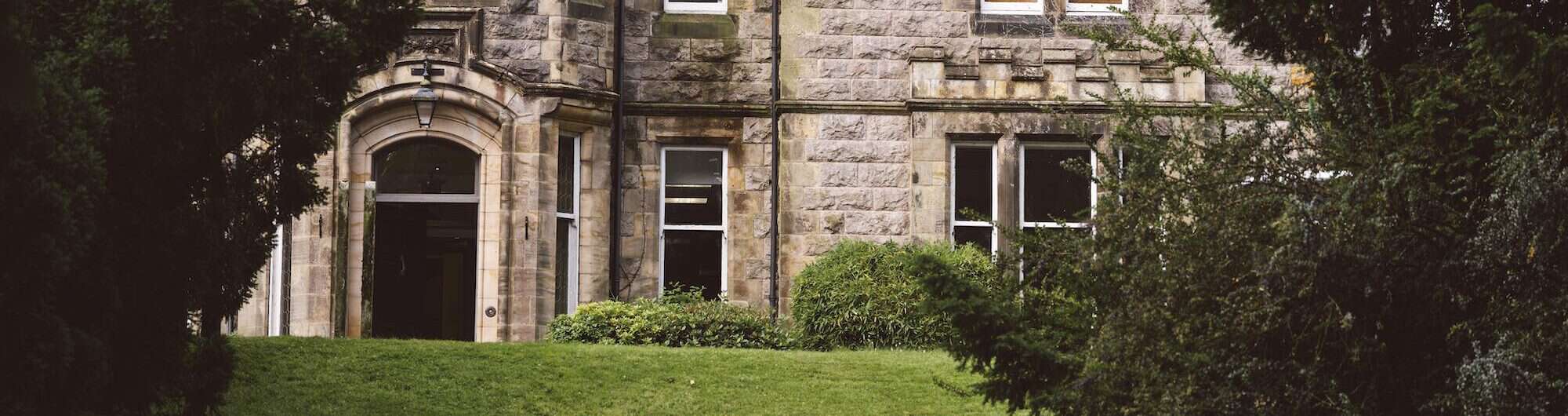 Elegant stone building with garden and greenery at Inchmarlo.
